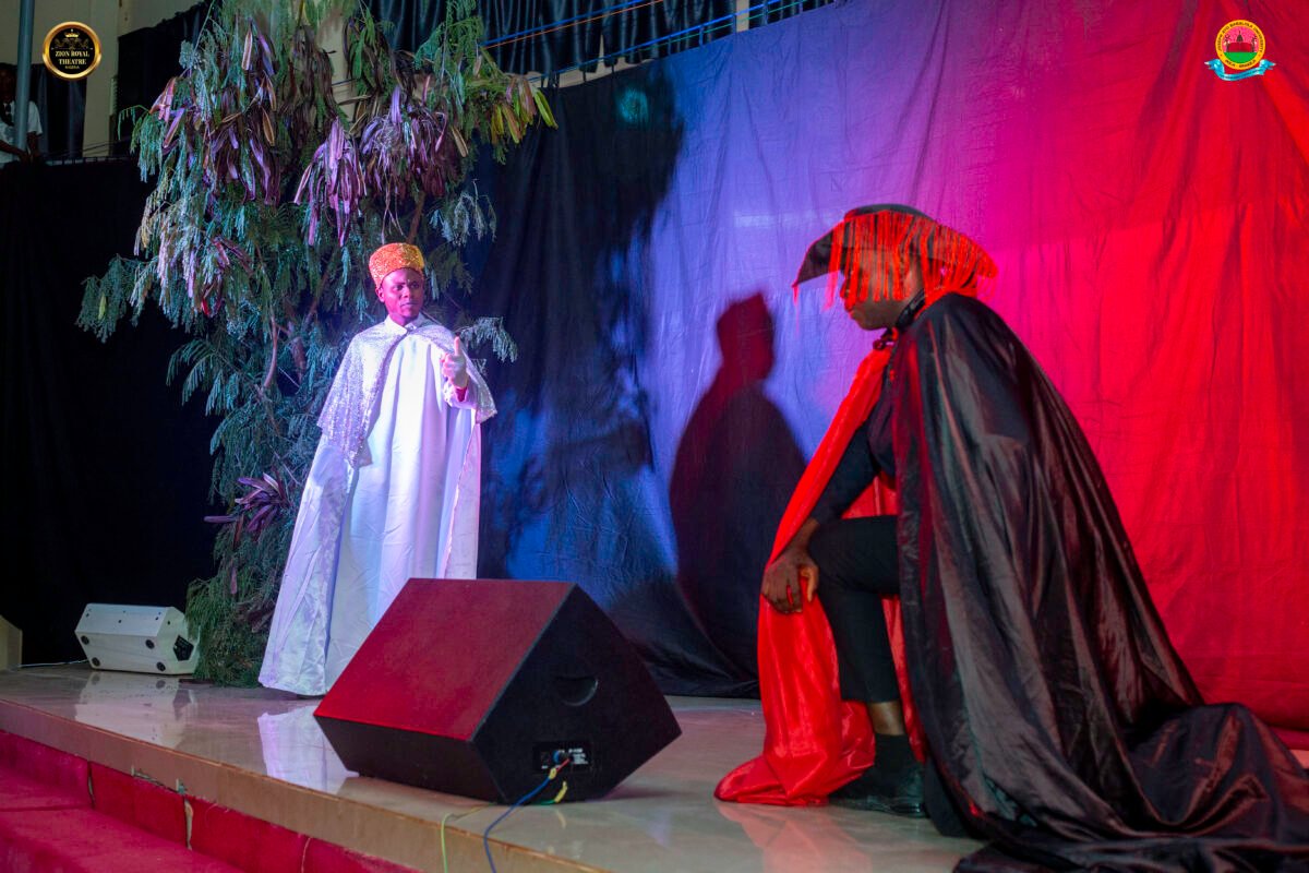 Stage scene showing costume made of white on one individual and another made of red on another individual