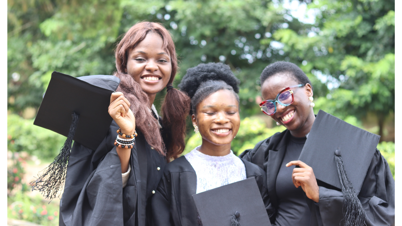 three students on dark blue matric gown facing the camera smiling